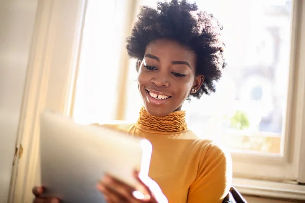 Jovem Mulher Afro Bonita Usando Tablet Sorrindo Interior — Fotografia de Stock