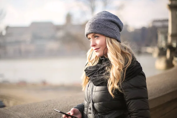 Молода Красива Блондинка Стоїть Дивиться Місто Мобільним Телефоном Руці Взимку — стокове фото