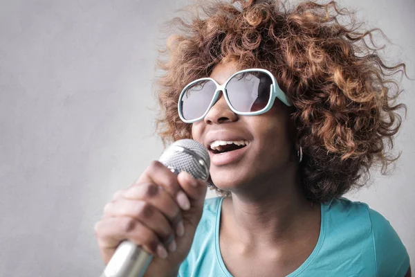 Jonge Afro Vrouw Zonnebril Zingen Met Een Microfoon Binnen — Stockfoto