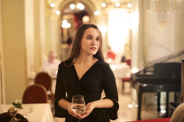 Young pretty woman in a restaurant with a glass in her hand.