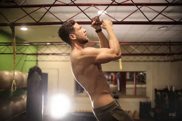 Spor salonunda egzersiz yapan genç atletik erkek.