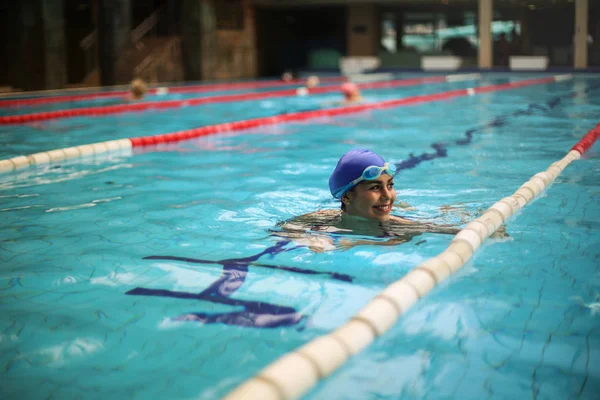 美丽的年轻女子游泳在游泳池 穿着游泳帽和游泳护目镜 — 图库照片