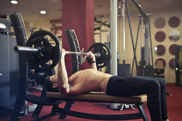 Joven Guapo Medio Desnudo Joven Haciendo Press Banca Gimnasio —  Fotos de Stock