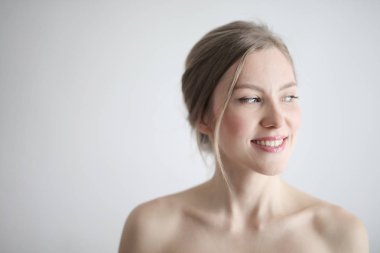 Olumlu seyir ve gülümseyen genç sarışın çıplak kadın.