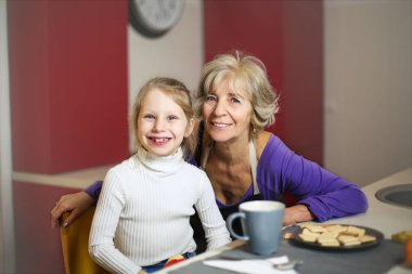 Yaşlı tür kadın ve Genç kız yemek masada oturan ve kameraya gülümseyen süre seyir.