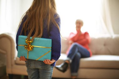 Genç kız bir hediye onun arkasından gizleme.