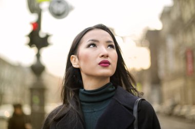 Şık kumaş üzerinde gökyüzüne bakarken güzel Asyalı kız.