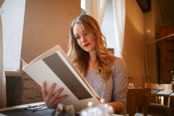 Piękna Młoda Kobieta Czytanie Menu Restauracji — Zdjęcie stockowe