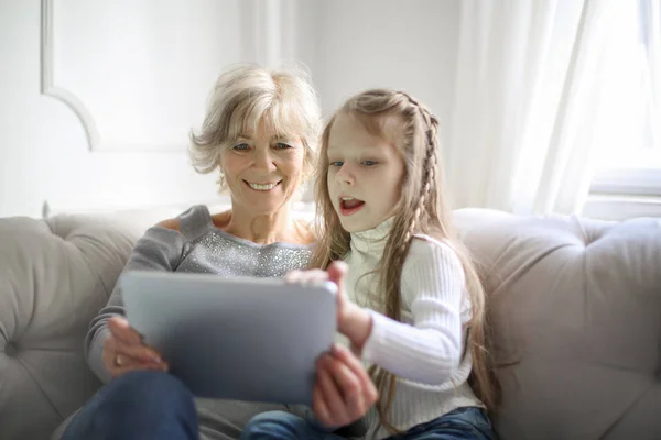 Amable Abuela Sonriente Leyendo Junto Con Nieta Mientras Está Sentada —  Fotos de Stock