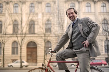 Zarif adam şehirde bisiklet üzerinde poz.