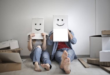 Kağıt kutular kafası üzerinde eğleniyor komik genç çift.