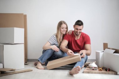 Genç çift kapalı yerde otururken kağıt kutuları etiketleme.