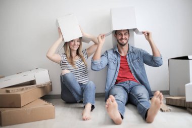 Genç çift katta otururken kağıt kutuları ile eğleniyor.