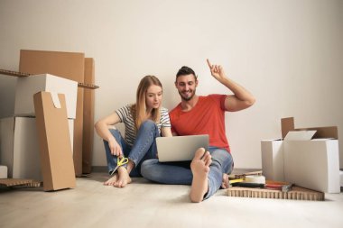 Mutlu genç çift onların laptop kontrol onların yeni ev.