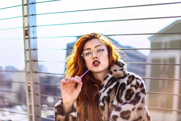 Gözlük şehir olan kızıl saçlı kadın.
