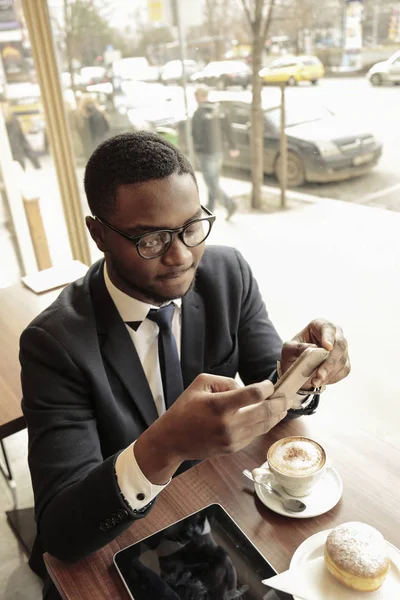 아프리카 사업가 비스트로에서 자신의 스마트폰 — 스톡 사진