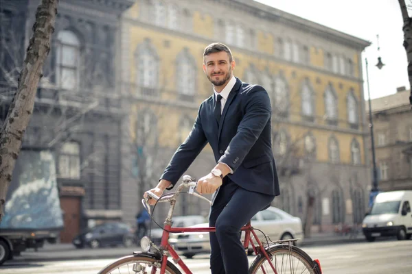 年轻的商人摆在自行车和微笑的城市 — 图库照片