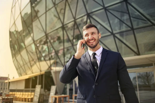 Joven Hombre Negocios Hablando Teléfono Inteligente Frente Edificio Moderno — Foto de Stock