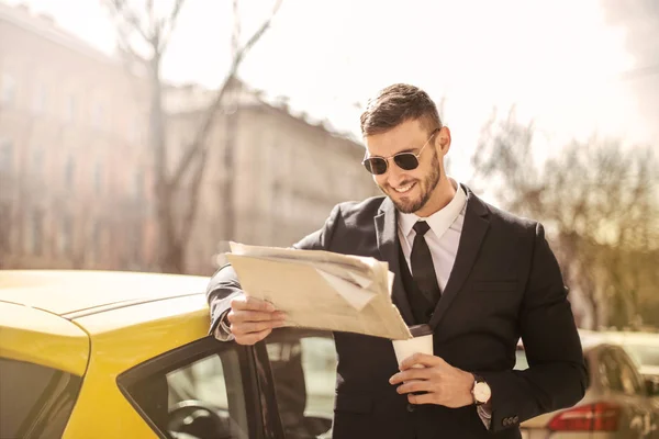 Młody Biznesmen Okulary Czytanie Gazety Obok Taksówkę — Zdjęcie stockowe