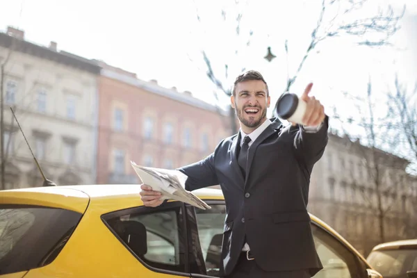 Joven Hombre Negocios Parado Junto Taxi Señalando Con Confianza —  Fotos de Stock