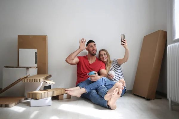 Jovem Casal Feliz Tomando Uma Selfie Enquanto Sentado Chão Interior — Fotografia de Stock