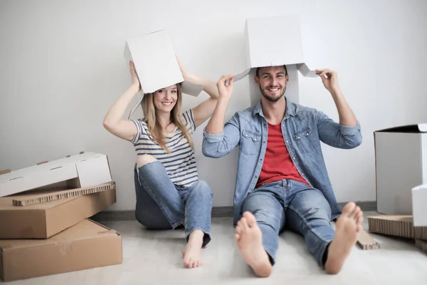 年轻夫妇坐在地板上玩纸盒的乐趣 — 图库照片