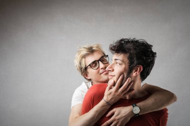 Eşcinsel çift gülümseyen ve birbirlerine sarılma.