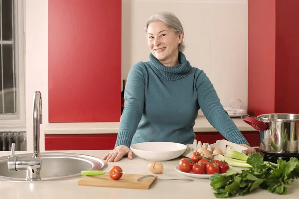 Feliz Abuela Pie Cocina Con Verduras Mesa —  Fotos de Stock