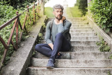 Kıvırcık saçlı adam ciddi bir merdiven arıyorum ve açık oturma.