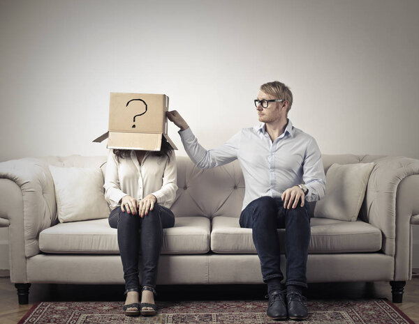 Couple sitting on a sofa and having questions in mind.