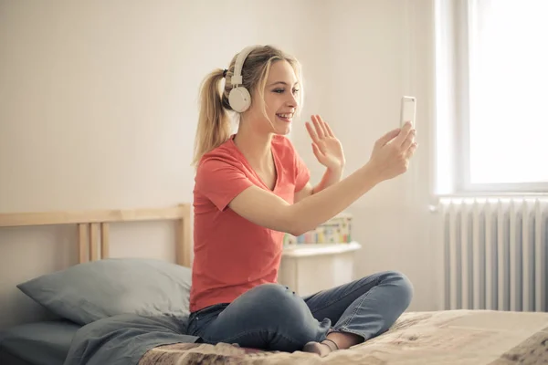 Sarışın Genç Kadın Yatağında Oturmuş Bir Selfie Alarak — Stok fotoğraf