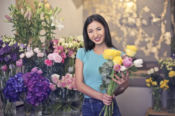 Young Asian florist with a bouquet in her hands.