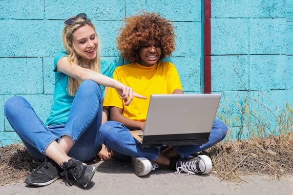 Two Young Female Friends Sitting Front Blue Wall Checking Laptop — Stock Photo, Image