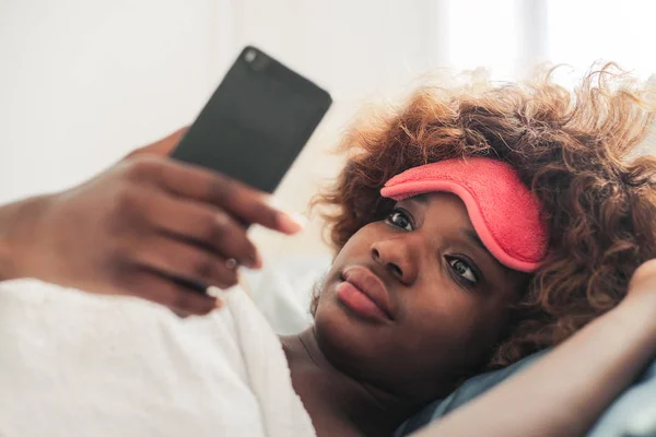 Joven Mujer Afro Con Máscara Dormir Rosa Revisando Teléfono Inteligente — Foto de Stock