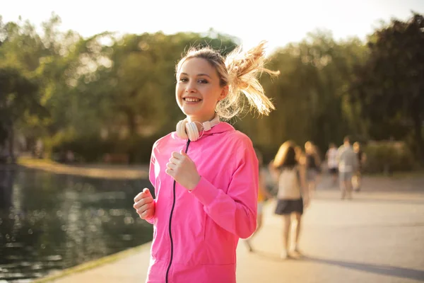 Fiatal Szőke Kocogás Parkban Egy Napsütéses Napon — Stock Fotó