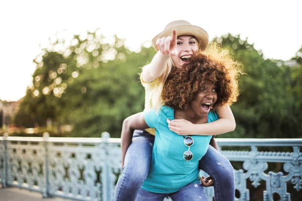 Gülen ve having fun sokakta iki genç bayan arkadaş.