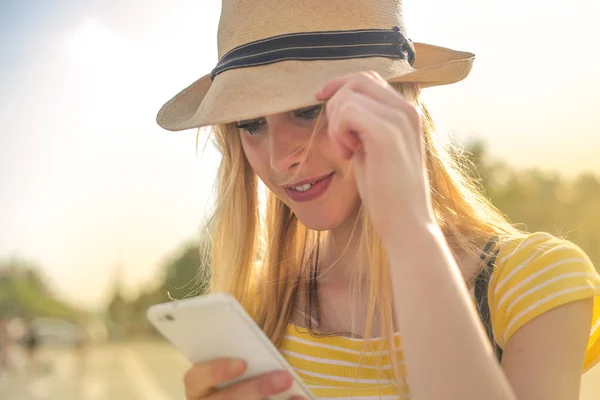 Hasır Şapka Onun Smartphone Kontrol Genç Güzel Sarışın Kadın — Stok fotoğraf