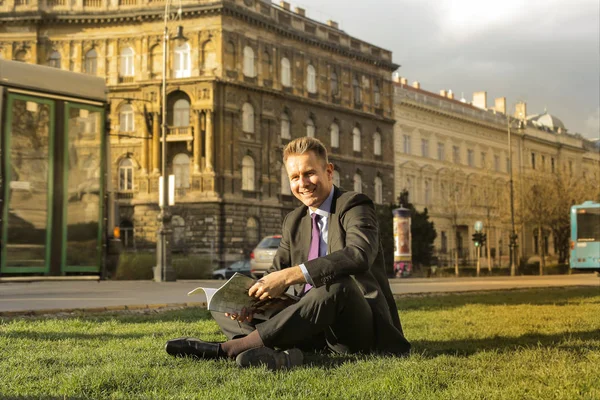 Empresário Sorrindo Sentado Com Jornal Cidade — Fotografia de Stock