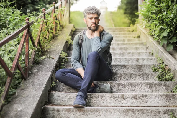 Kıvırcık saçlı adam ciddi bir merdiven arıyorum ve açık oturma.