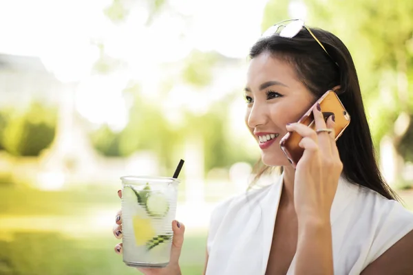 Bir Limonata Sahip Smartphone Açık Konuşmak Zarif Güzel Asyalı Kadın — Stok fotoğraf