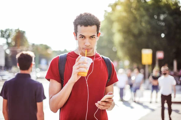 Ung Afro Man Med Hörlurar Promenader Och Dricka Juice Staden — Stockfoto