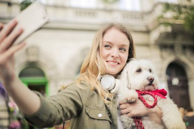 Güzel sarışın kadın onun sevimli köpek ile bir selfie alarak.