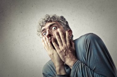 Kıvırcık saçlı adam şaşırmış ve korkmuş seyir.