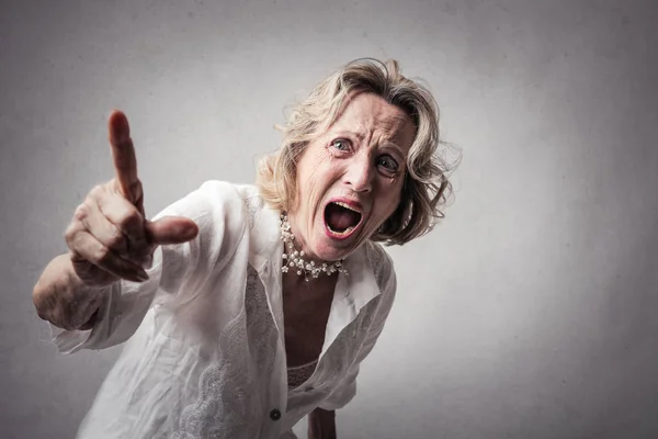 Senior Blonde Woman Shouting Angrily Pointing Away — Stock Photo, Image