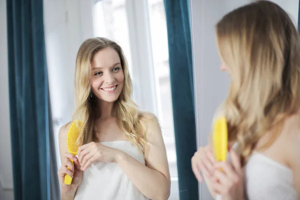 Jovem Mulher Loira Bonita Escovando Seu Cabelo Com Uma Escova — Fotografia de Stock