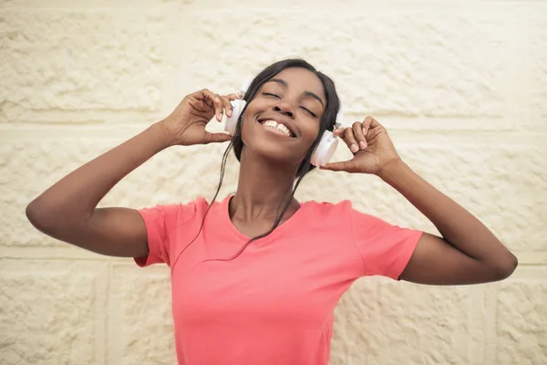 若い美しい黒人女性彼女のヘッドフォンで音楽を聴く — ストック写真
