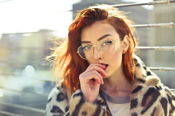 Güneşli bir günde bir köprü kentin ayakta şık gözlüklü genç güzel kadın.