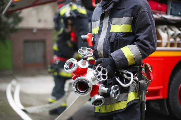 Feuerwehrleute Mit Schlauch Und Gerät Einsatz — Stockfoto