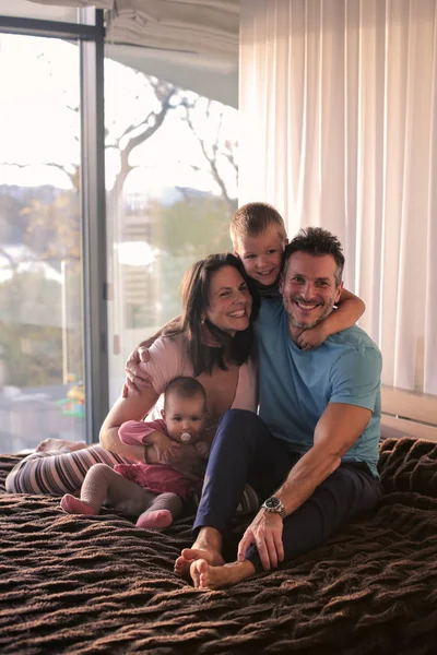 Jovem Família Feliz Com Duas Crianças Sorrindo Divertindo Uma Cama — Fotografia de Stock