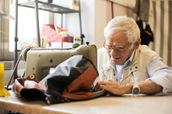 Ένας Ηλικιωμένος Άνδρας Γυαλιά Ράψιμο Μια Ράβοντας Μηχανή Ένα Εργαστήριο — Φωτογραφία Αρχείου